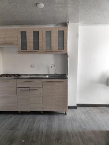 een keuken met houten kasten en een wastafel in de kamer bij Apartamento vía a termales in Santa Rosa de Cabal