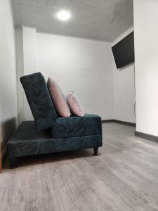 a green couch with two pillows on it in a room at Apartamento vía a termales in Santa Rosa de Cabal