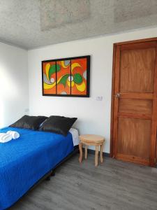 - une chambre avec un lit bleu et une porte en bois dans l'établissement Apartamento vía a termales, à Santa Rosa de Cabal
