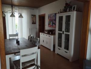 uma cozinha com uma mesa de jantar e um armário branco em Unterkunft FERIENHAUS TRAUDL & PAUL 