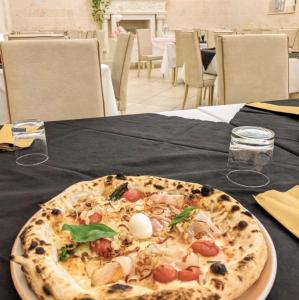 eine Pizza auf einem Tisch in der Unterkunft Castello Conti Filo in Torre Santa Susanna