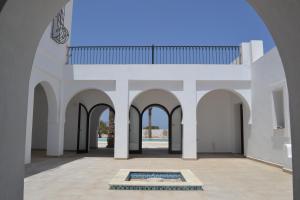 a view of the courtyard of a building with a pool at Maison Rachid Djerba in El Guecheïne