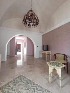 a living room with a table and a chandelier at Maison Rachid Djerba in El Guecheïne
