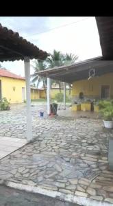 a stone yard with a building and a stone patio at Chácara in Estância