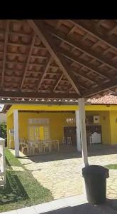 a yellow house with a patio with tables and chairs at Chácara in Estância