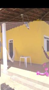 a room with a table and a yellow wall at Chácara in Estância