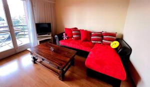 uma sala de estar com um sofá vermelho e uma mesa em Villars Soleil em Villars-sur-Ollon