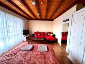 uma sala de estar com um sofá e almofadas vermelhas em Villars Soleil em Villars-sur-Ollon