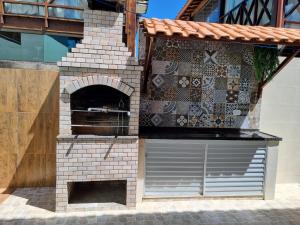 un horno de pizza al aire libre con una pared de ladrillo en Praia dos Carneiros casa com 4 quartos, en Tamandaré