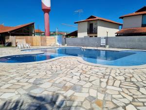 una piscina con suelo de piedra y un edificio en Praia dos Carneiros casa com 4 quartos, en Tamandaré
