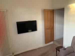 uma sala de estar com uma televisão de ecrã plano na parede em Holiday Home in Kidderminster em Kidderminster