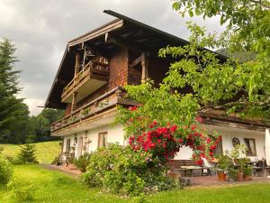 een huis met rode bloemen ervoor bij Bergromantik Apartments Fritzenlehen in Berchtesgaden