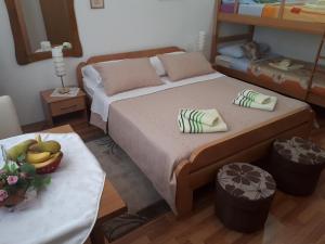 Un dormitorio con una cama y una mesa con un bol de fruta en Guest House Family Varda Plitvice Lakes en Plitvička Jezera