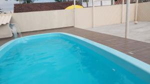 una gran piscina azul en el patio trasero en Casa com Piscina na Praia, en Balneário Barra do Sul