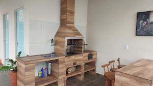 cocina con fregadero y armario de madera en Casa com Piscina na Praia, en Balneário Barra do Sul