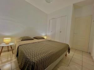 1 dormitorio con 1 cama y 1 mesa con 2 lámparas en PETIT CAPUCIN en Carcassonne