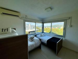 sypialnia z 2 łóżkami i dużym oknem w obiekcie Casa Calma Puerto del Aguila w mieście Potrero de Garay