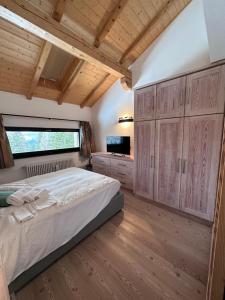 1 dormitorio con 1 cama grande y armarios de madera en CAMPIGLIO Panorama sul Brenta en Madonna di Campiglio