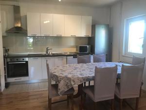 een keuken met een tafel en stoelen en een keuken met witte kasten bij City Retro Chic Apartment Magdalena Trogir in Trogir