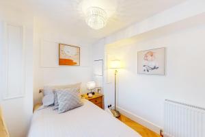 een witte slaapkamer met een bed en een lamp bij Park Lane Apartments Harrowby street in Londen