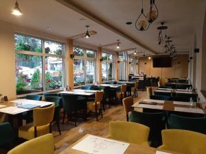 a dining room with tables and chairs and windows at Hotel Pepa in Divčibare