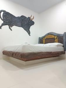 a wooden bed with a cow head on a wall at HOTEL EL EMPERADOR in Doradal