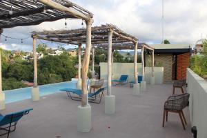 acovered patio with chairs and a swimming pool at Maramara more to live in Sayulita