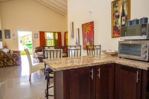 a kitchen and living room with a counter and a microwave at Ocho Rios Drax hall Manor 3 Bed sleeps 7 in Saint Annʼs Bay