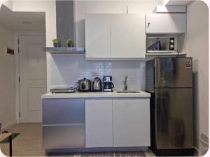 a kitchen with white cabinets and a stainless steel refrigerator at Azure urban residences 1BR Unit fits max 3 persons in Manila