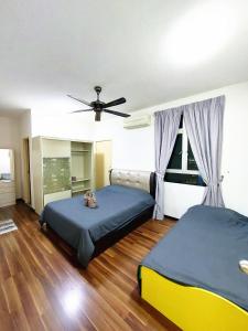 a bedroom with two beds and a ceiling fan at TuR15 PisaStadium 9pax 4rooms PrivateHouse in Bayan Lepas