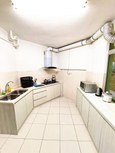 a kitchen with white cabinets and a sink and a window at TuR15 PisaStadium 4rooms PrivateHouse in Bayan Lepas