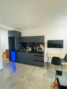 una cocina con armarios negros y una mesa con sillas en lovely flat in the center 36, en Tel Aviv