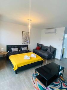 1 dormitorio con cama amarilla y sofá en lovely flat in the center 36, en Tel Aviv