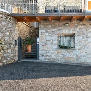 um edifício de tijolos com uma porta e uma varanda em Lucalì Mountain Room em Ponte di Legno