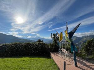 a group of wind sculptures sitting on a deck at First Class Hotel en Baños - Ciudad Volcan in Baños