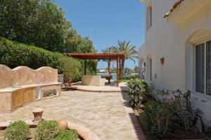 a backyard with a stone patio with a bench at White Villa with open lagoon view in Hurghada
