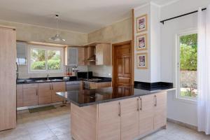 a kitchen with wooden cabinets and a black counter top at White Villa with open lagoon view in Hurghada