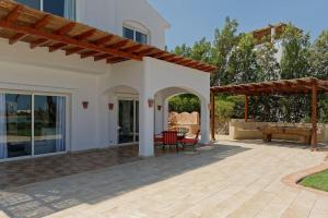 a patio of a house with a table and chairs at White Villa with open lagoon view in Hurghada +4 photos