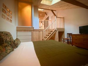 a bedroom with a bed with a television and a staircase at La Ferme de Mehachamp in Remiremont