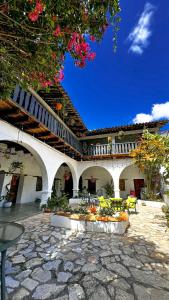 a building with a patio with yellow chairs and flowers at Garden Hotel in Copán Ruinas