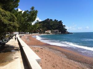 a person walking on a beach near the ocean at Regent Apartment in Petrovac na Moru