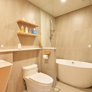 a bathroom with a toilet and a tub and a sink at Gyeongju Hanok Sohwa in Gyeongju