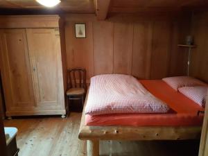 1 dormitorio con 2 camas en una habitación con paredes de madera en Alphütte Chilchschwand - b48558, en Stalden
