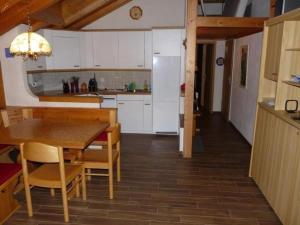 uma cozinha com armários brancos e uma mesa e cadeiras em Chalet Kiefer - b48527 em Grindelwald