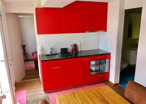 a red kitchen with a sink and a stove at Pilgerwohnung - b48531 in Wald