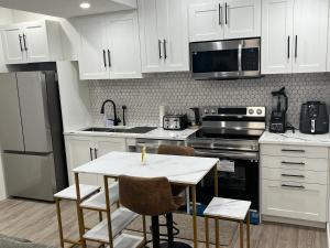 a kitchen with white cabinets and a table with a candle on it at Beautiful 2 Bedroom Guest Suite in Leduc 11 mins to Edmonton Intl Airport, Free Wifi, Netflix ,Cable & Workstation in Leduc