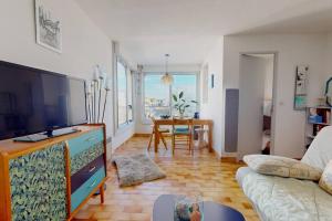 een woonkamer met een televisie en een bank bij Beau studio, plage, port. in Cap d'Agde