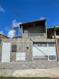 uma casa com duas portas brancas de garagem em Confortável Kitinete Duplex em Fortaleza