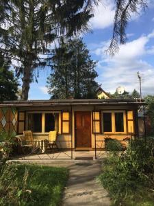 a tiny house with a porch and a patio at Ferienhaus in Oranienburg mit Terrasse, Grill und Garten in Oranienburg