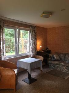 uma sala de estar com uma mesa e um sofá em Ferienhaus in Oranienburg mit Terrasse, Grill und Garten - b48564 em Oranienburg